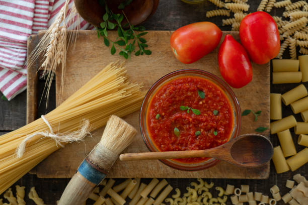 istock Tomato sauce and raw pasta composition 1213675797