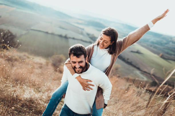 istock Young cheerful couple having fun while piggybacking on a hill. 1213676453
