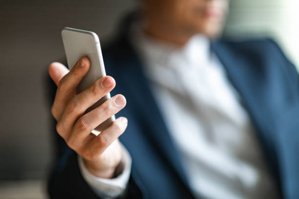 istock Close up of unrecognizable businessman using mobile phone. 1213678144