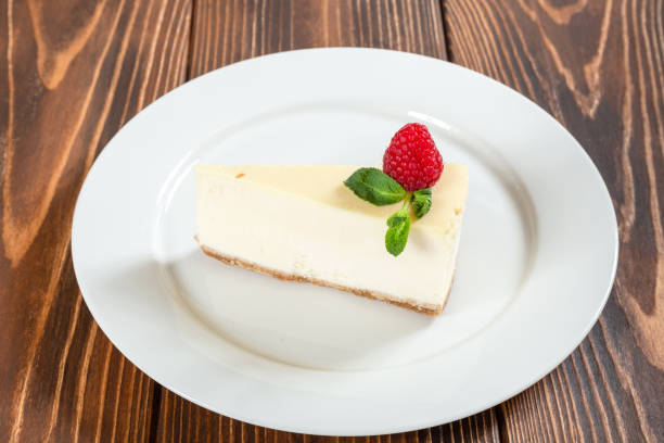 Cheese cake with mint leaves and strawberry on white plate stock photo