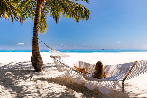 istock Woman relaxing in hammock in a shade on the beach. 1213682399