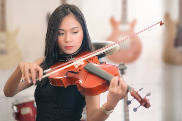 Beautiful asian woman playing violin.