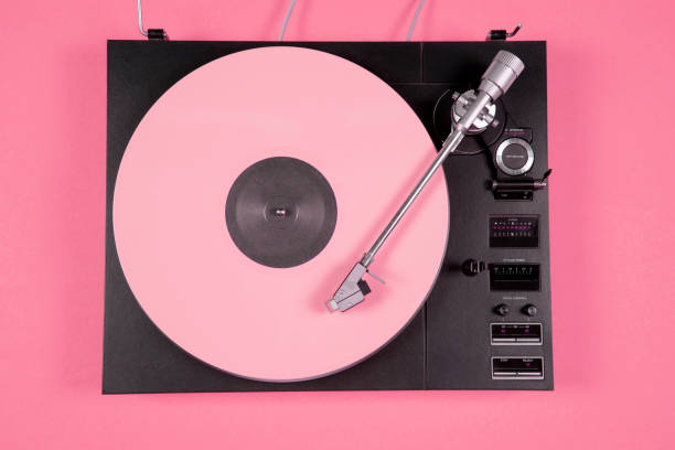 disco in vinile colorato su sfondo rosa con spazio di copia. vista dall'alto. - soundtracks foto e immagini stock
