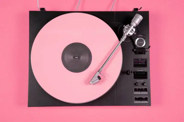 Photo of Colored vinyl record on a pink background with copy space. Top view.