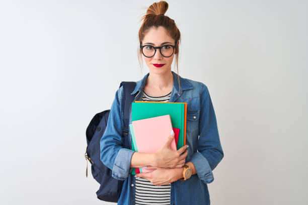 istock Redhead student woman wearing backpack holding books over isolated white background with a confident expression on smart face thinking serious 1213689438
