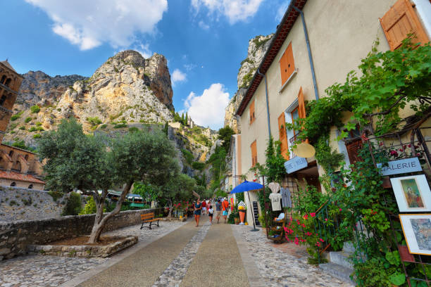 Tourists in the narrow street of thel medieval village Moustiers Sainte Marie, France" Moustiers Sainte Marie, France - Jul 4, 2019: Tourists in the narrow street of the medieval village Moustiers Sainte Marie. Village is included in list of "The most beautiful villages of France" sainte marie stock pictures, royalty-free photos & images