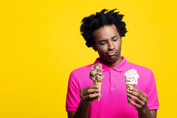istock Young man holding chocolate and vanilla gelato in hands 1213689938