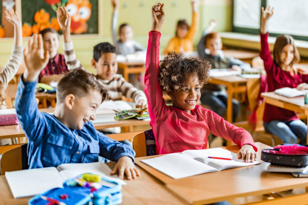 istock Large group of happy elementary students know the answer on a class in the classroom. 1213694128