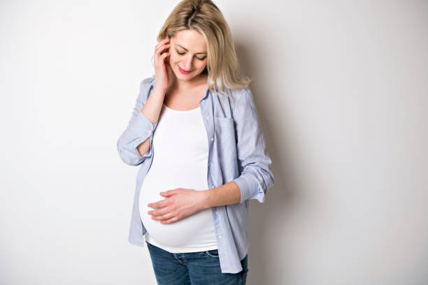 istock pregnant woman caressing her belly over white background 1213694955