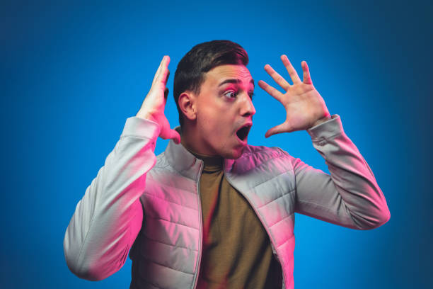 istock Caucasian man's portrait isolated on blue studio background in neon light 1213696567