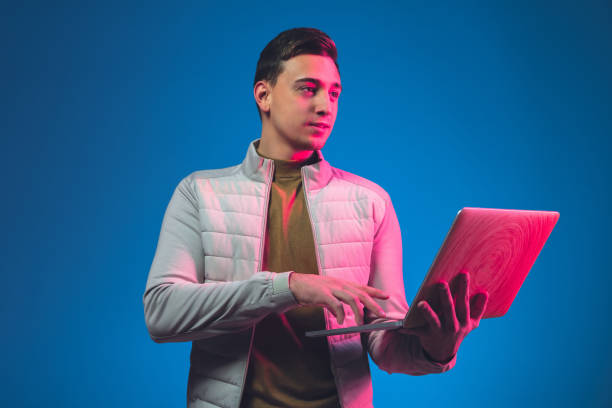 Caucasian man's portrait isolated on blue studio background in neon light