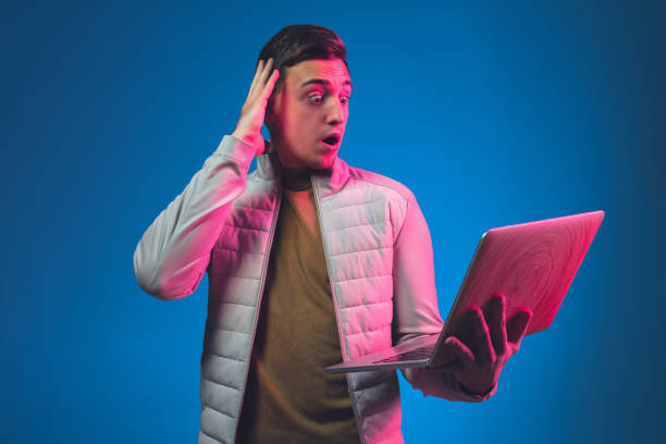 istock Caucasian man's portrait isolated on blue studio background in neon light 1213696610