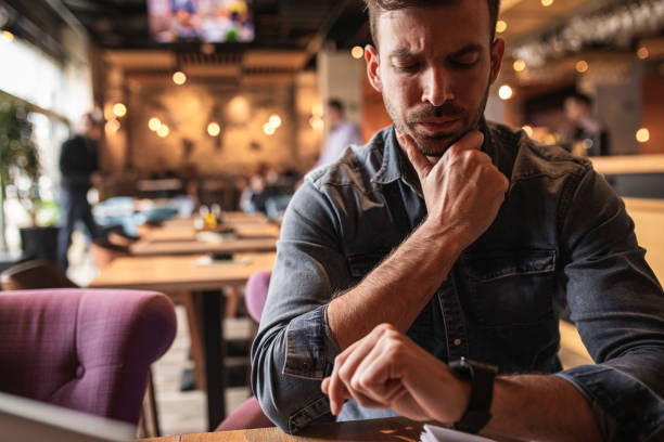 istock Young man sitting at cafe shop and working on laptop. 1213696632