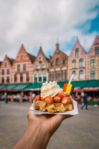 brujas waffles bélgica, waffle con crema y fresa, waffle aislado en mano - waffle belgian waffle belgian culture isolated fotografías e imágenes de stock