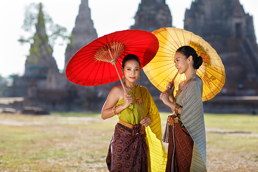 Woman in Thai traditional costume with ancient pagoda at temple at Ayutthaya