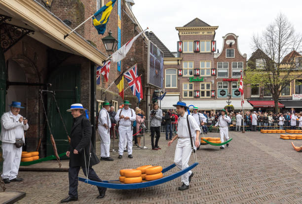 Carriers walking with many cheeses in the famous Dutch cheese market in Alkmaar Alkmaar, Netherlands - April 21, 2017: Carriers walking with many cheeses in the famous Dutch cheese market in Alkmaar, The Netherlands. The event happens in the Waagplein square. cheese dutch culture cheese making people stock pictures, royalty-free photos & images