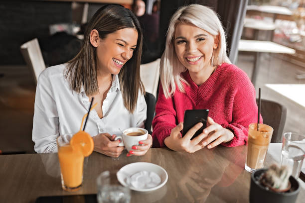 istock Young women using smart phone at coffee shop 1213699773