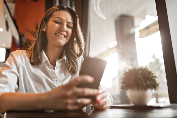 istock Woman using phone in coffee shop 1213699873
