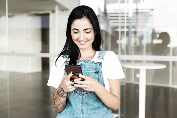 istock Smiling young woman using smartphone 1213701523