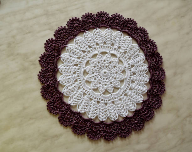 istock White and purple hand hooked coaster. Knitted holders for hot work 1213701592