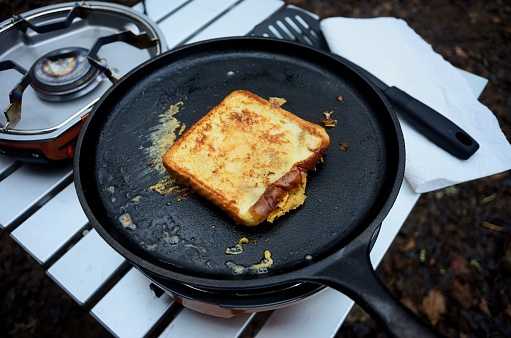 Close up of cooking a grill cheese sandwich on griddle camp stove