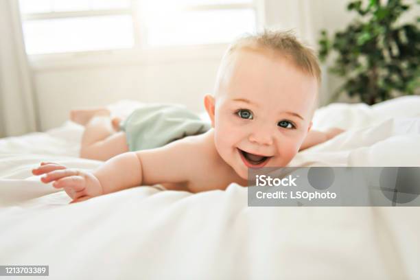 Cute Baby Boy Lying On A White Bed Stock Photo - Download Image Now - Baby - Human Age, Happiness, Babies Only