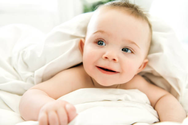 istock cute baby boy lying on a white bed 1213703995