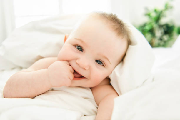 istock cute baby boy lying on a white bed 1213704190