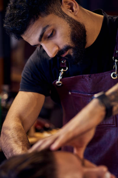 istock Shaving process of beards in Barbershop. Master makes the client shave his beard with vintage straight razor. 1213704653