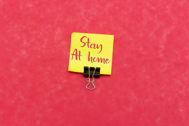 istock sticky note with stay at home isolated on pink background 1213704815