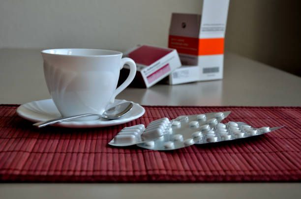 Drug boxes and blister together with a white coffee mug.