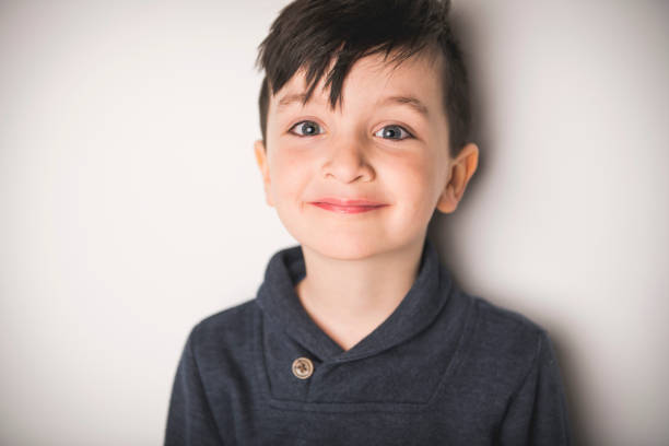 A close portrait of a five years old boy over white