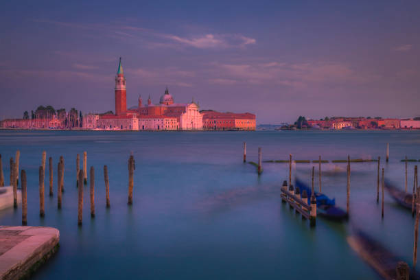 Long exposure: ethereal San Giorgio Maggiore and gondolas at sunset - Venice, Italy Long exposure: blurred ethereal San Giorgio Maggiore cathedral at sunset - Venice, Italy venice italy grand canal honeymoon gondola stock pictures, royalty-free photos & images