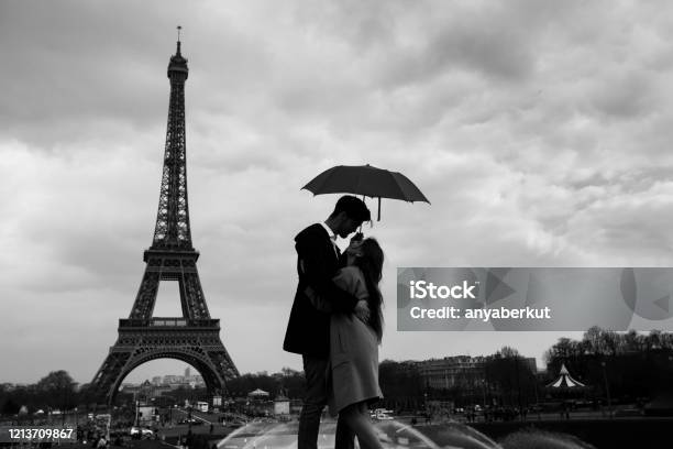 Retro View Of Paris Couple Under Umbrella Near Eiffel Tower Vintage Stock Photo - Download Image Now