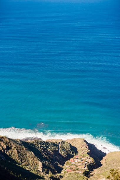 Clear blue water at a rocky beach on Madeira island in the Atlantic Ocean during a beautiful summer day.