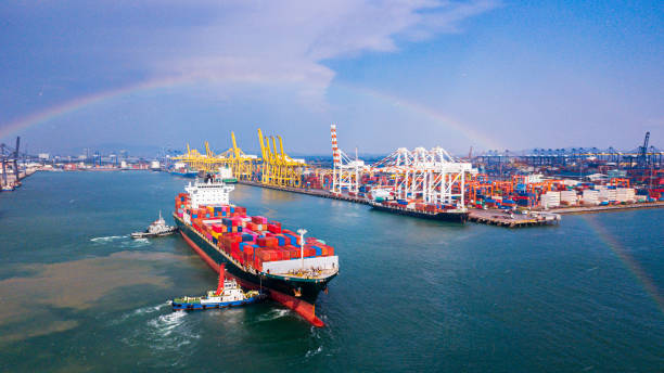 nave cargo che attracca porto merci in una giornata piovosa e con un arcobaleno - rainbow harbor foto e immagini stock