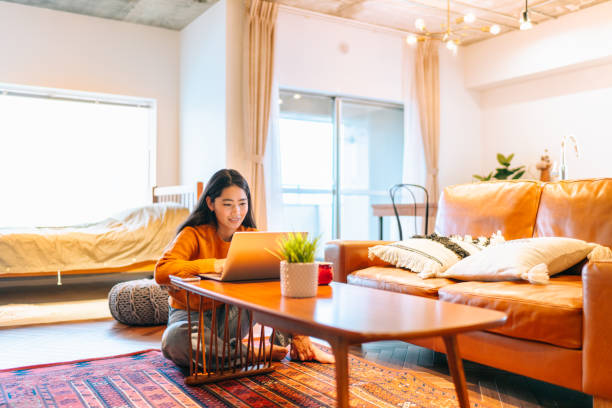 istock Young woman using laptop comfortably at home 1213716026