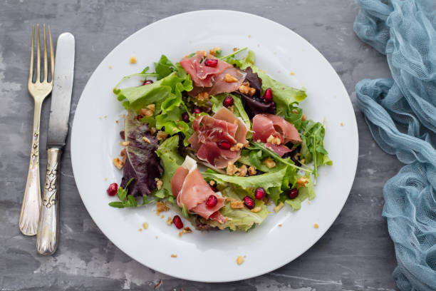 istock salad prosciutto with pomegranate on white plate 1213717192