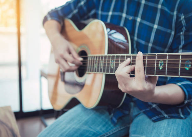 istock A man playing acoustic guitar in home 1213722900