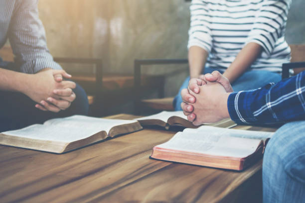 istock christian small group holding hands and praying together 1213722913