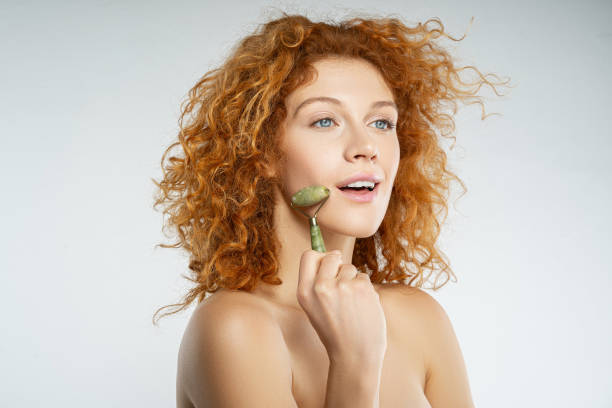 istock Girl massaging her cheek with a jade roller 1213724024