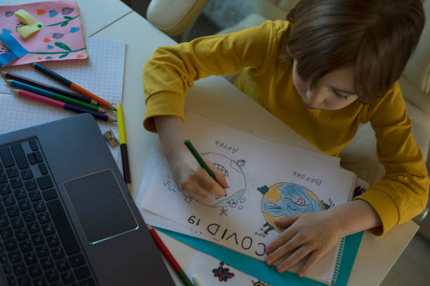 istock Little boy attending to online school class 1213724038