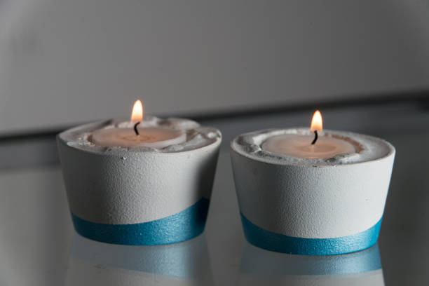 istock Two candles in white and blue concrete candle holders 1213724122