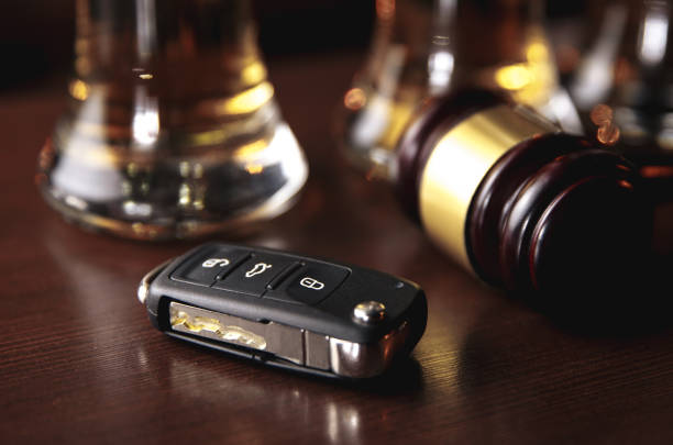 istock Drinking and driving concept. Car key on a wooden table, pub 1213727120