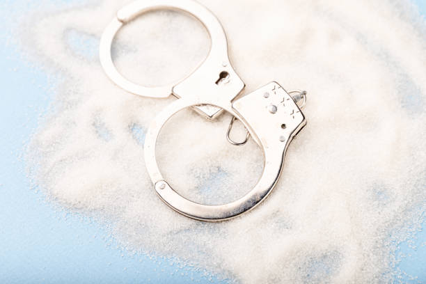 istock Sugar is dangerous. Handcuffs on the table. Sweet dependence. 1213728861