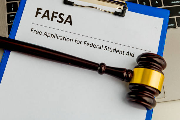 istock Fafsa. Student aid concept. Application form of document on the table with wooden hammer isolated. 1213728938