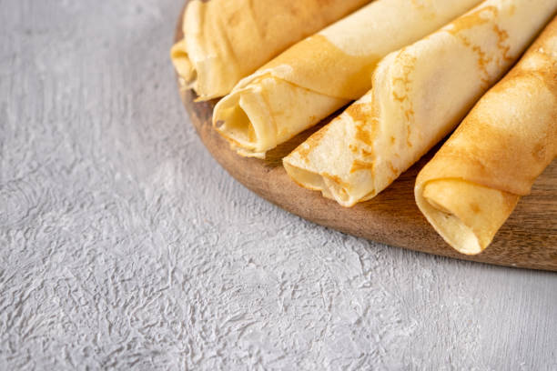 istock Golden crepes on a wooden board. Breakfast time. 1213729011