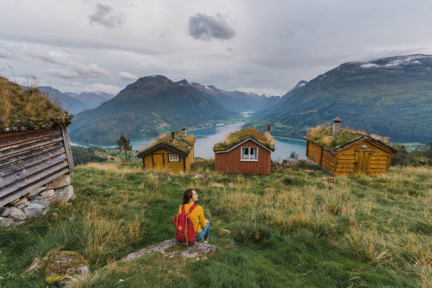 istock Woman sitting near the  huts in moss 1213731608