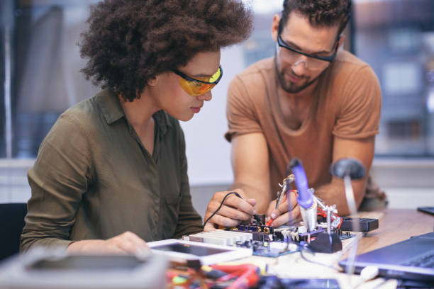 istock Co-workers working late on a circuit boards in office 1213731878