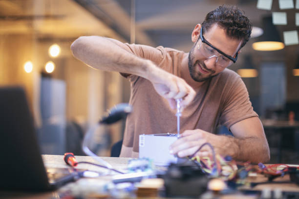istock Co-workers working late on a circuit boards in office 1213732528